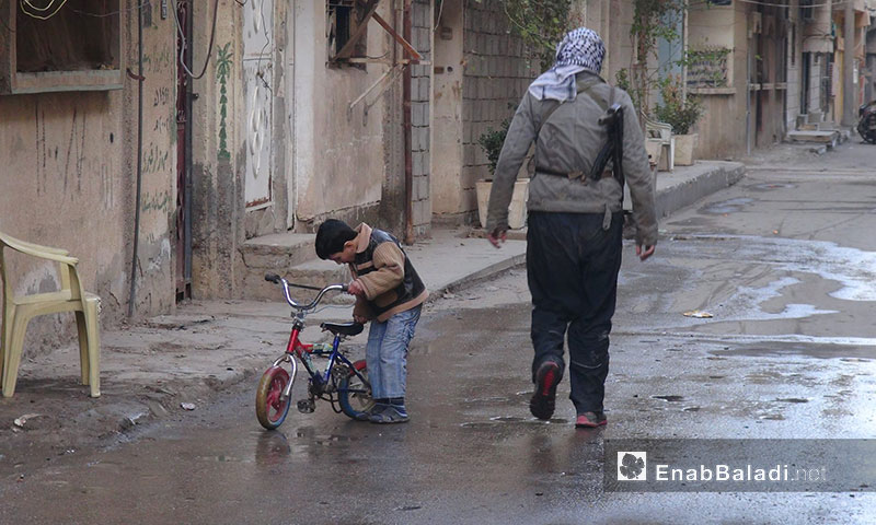 طفل مع مقاتل حي الشيخ ياسين في دير الزور - 2013 (عنب بلدي)