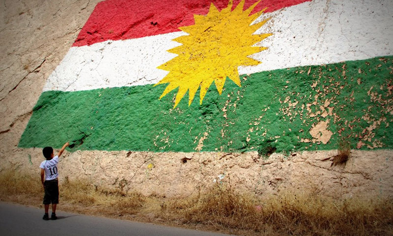 طفل كردي يشير إلى علم "كردستان" في العراق (إنترنت)