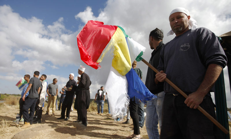 مجموعة من أبناء السويداء يرفعون راية الدروز في ريف المحافظة (AFP)