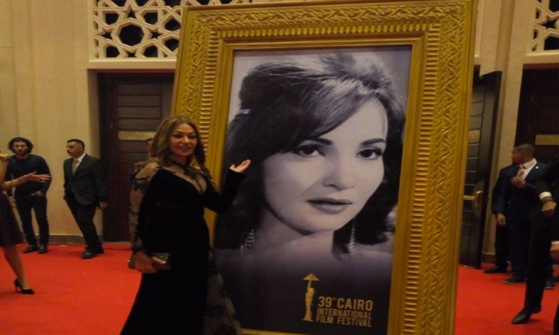 الممثلة المصرية ليلى علوي أمام صورة تكريمية للفنانة شادية (إنترنت)