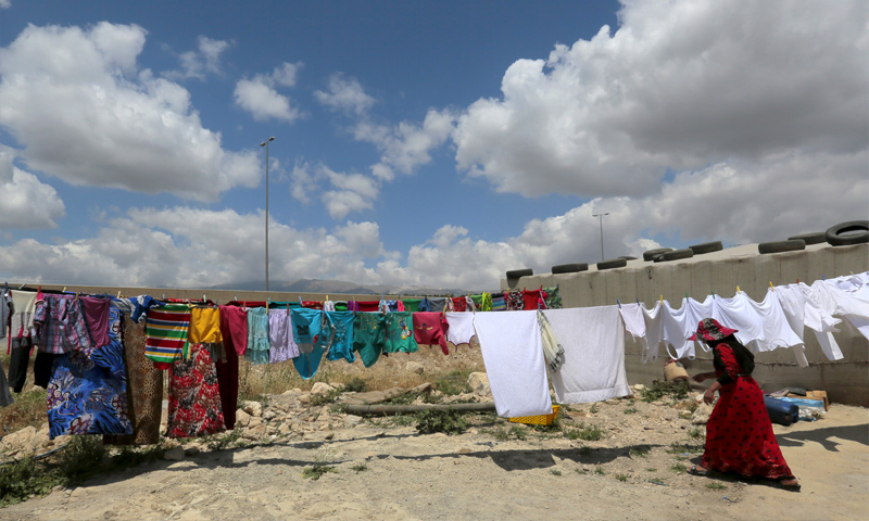 امرأة سورية تعلق الملابس في مخيم بر إلياس في البقاع اللبناني - 20 حزيران 2015 (Jamal Saidi)