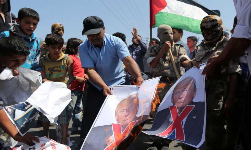 إحراق صور الرئيس الأمريكي، دونالد ترامب، في غزة (صحيفة الوطن الفلسطينية)