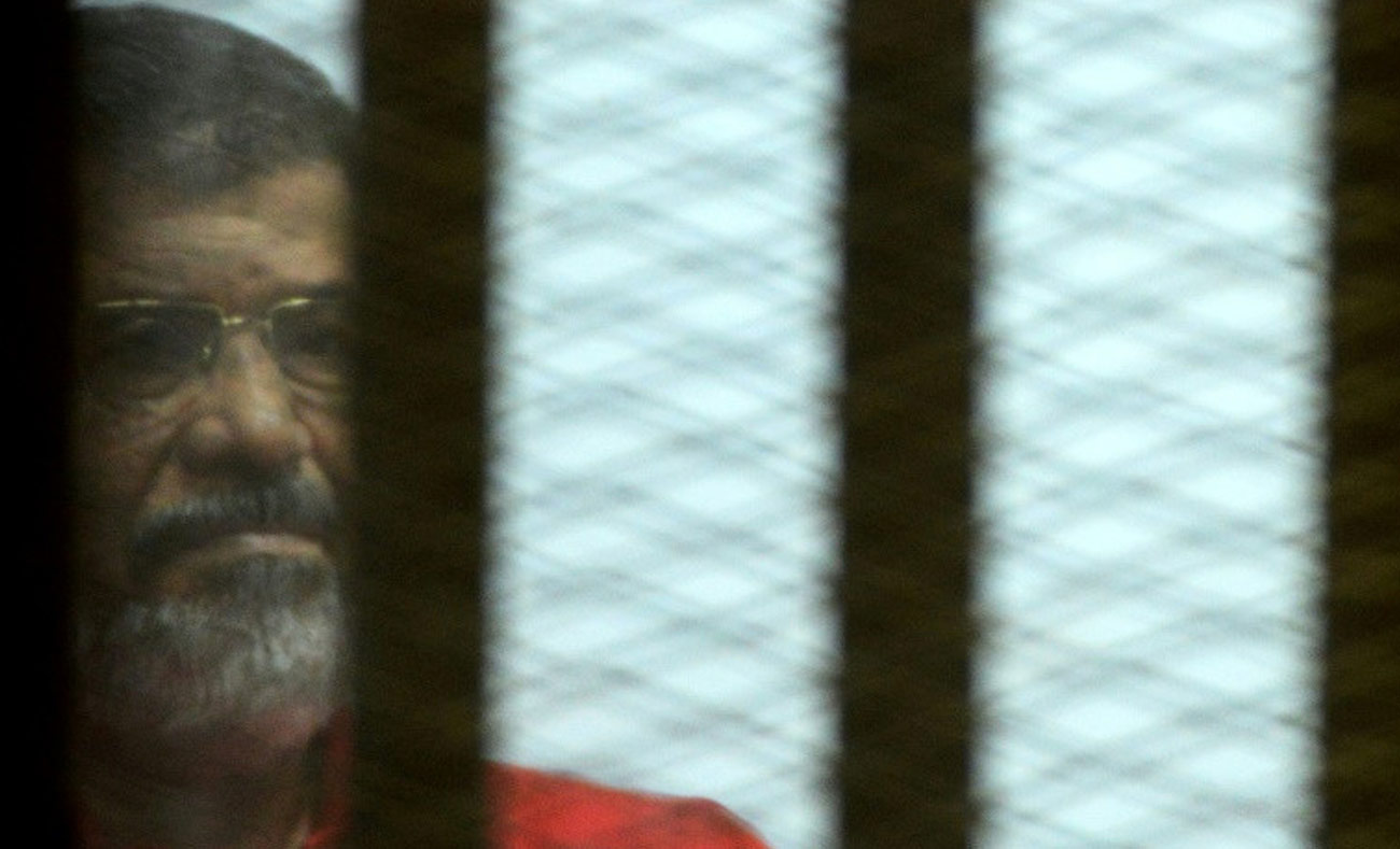 الرئيس المصري السابق، محمد مرسي، خلال أحد محاكماته (AFP)