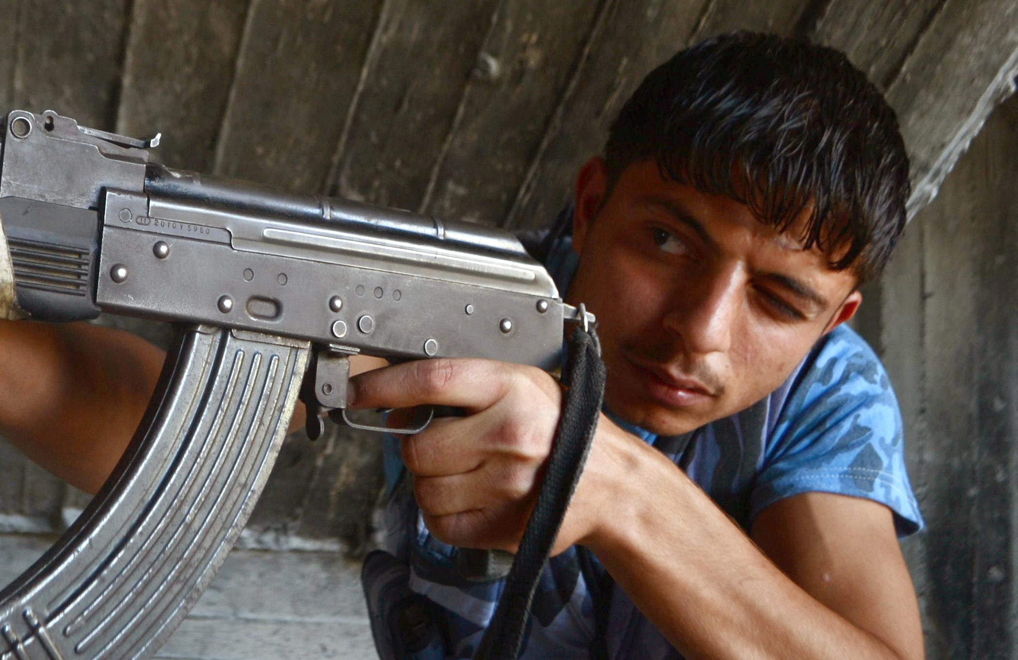 شاب سوري من المعارضة السورية يوجه سلاحه في مدينة حلب (AFP)
