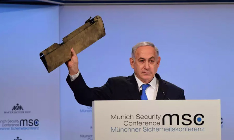 رئيس الوزراء الإسرائيلي بنيامين نتنياهو يحمل بقايا طائرة استطلاع إيرانية في مؤتمر الأمن العالمي بميونخ (GPO)