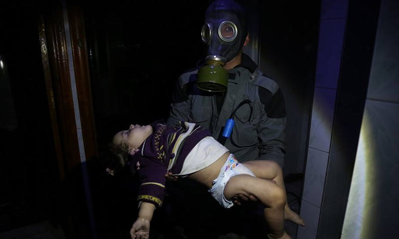 عنصر من الدفاع المدني يحمل طفلة مصابة بالغازات السامة في دوما بالغوطة الشرقية - 7 من نيسان 2018 (الدفاع المدني في دمشق وريفها)