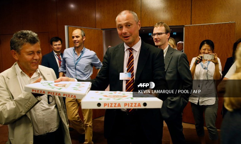 الكولونيل ألكسندر زورين يوزع البيتزا على صحفيين في جنيف - أيلول 2016 (AFP)