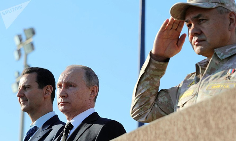 بشار الأسد مع الرئيس الروسي فلاديمير بوتين ووزير دفاعه في قاعدة حميميم - (سبوتنيك)