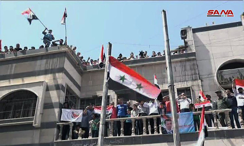 النظام السوري يرفع العلم السوري على مبنى مجلس بلدة يلدا جنوبي دمشق - 11 من أيار 2018 (سانا)