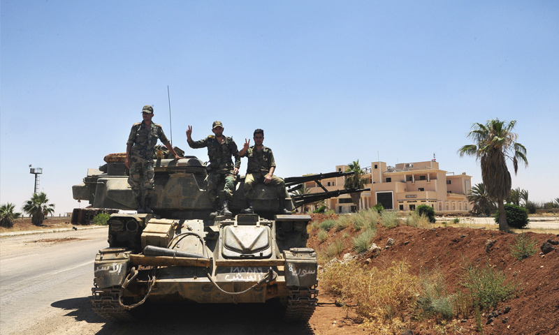 عناصر من قوات الأسد يرفعون إشارة النصر بعد السيطرة على معبر نصيب الحدودي - 7 من تموز 2018 (AP)