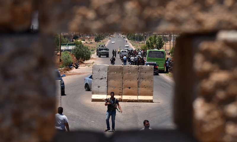 توقف حافلة عند نقطة تفتيش في أثناء عودة نازحين من محافظة درعا إلى بلدتهم في بصرى الشام - 11 تموز 2018 (AFP)