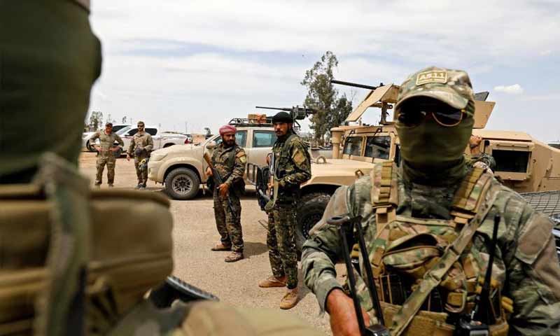 جنود أمريكا ومقاتلون من "قوات سوريا الديمقراطية" في حقل التنك النفطي شرق دير الزور - 1 أيار 2018 (AFP)