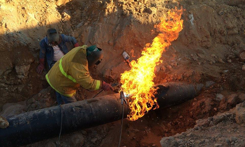 عمال في وزارة النفط السورية يعملون على صيانة أنابيب النفط (رئاسة مجلس الوزراء)