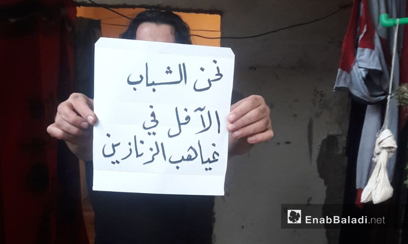معتقل يرفع لافتة في سجن حماة رفضًا لأحكام الإعدام - 12 من تشرين الثاني 2018 (عنب بلدي)