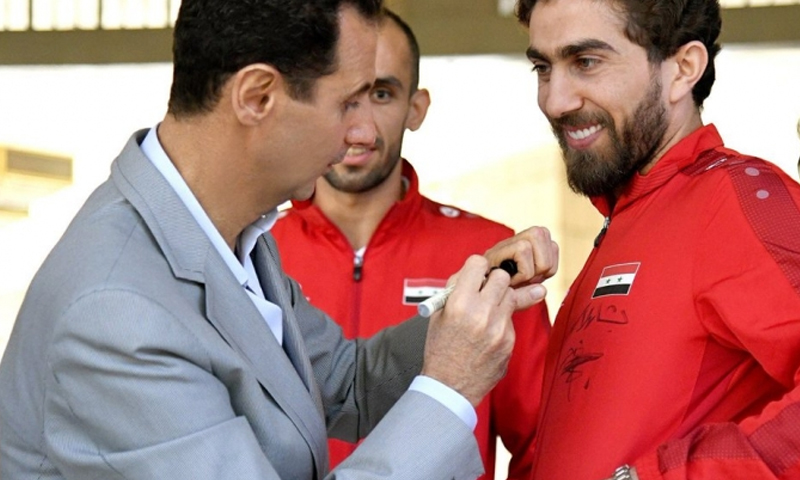 رئيس النظام السوري، يوقع على قميص اللاعب فراس الخطيب (سانا)