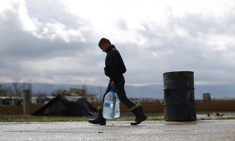 تعبيرية: طفل سوري يحمل عبوات مياه في مخيم الفيضاء شرق بيروت (AP)