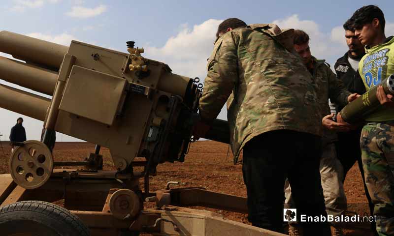 مقاتلون من جيش العزة بريف حماة الشمالي، أثناء تجهيزهم راجمة صواريخ آذار 2019 (عنب بلدي)