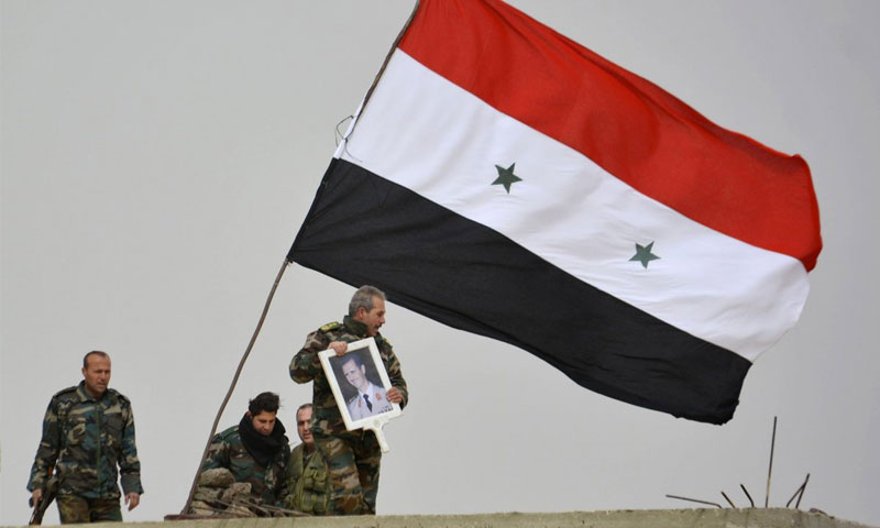 مقاتلون يرفعون صورة رئيس النظام السوري بشار الأسد بعد السيطرة على تل العدس بريف دمشق - 10 شباط 2015 (روتيزر)