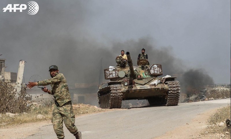 عناصر من الجبهة الوطنية للتحرير في أثناء توجههم للمشاركة في معركة بريف حماة الشمالي - 6 من حزيران 2019 (AFP عمر حاج قدور)