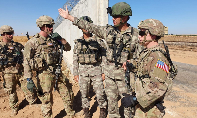 جنود أتراك وأمريكيون على الحدود السورية التركية في أثناء تسيير دورية برية شمالي سوريا - (رويترز)
