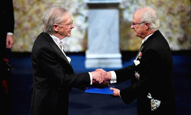الكاتب النمساوي بيتر هاندك يصافح ملك السويد كارل جوستاف أثناء حصوله على جائزة نوبل لعام 2019 خلال حفل توزيع جوائز نوبل في قاعة ستوكهولم للحفلات الموسيقية في ستوكهولم السويدية - 10 كانون الأول 2019 (رويترز)