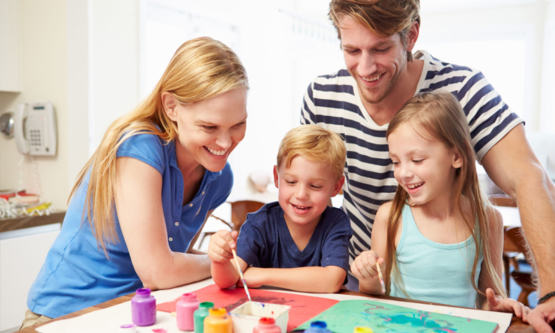 صورة تعبيرية لعائلة تعلم أطفالها على الرسم (FINDING HAPPINESS)