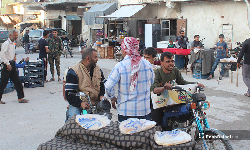 أشخاص يشترون الخبز في بلدة سرمين بريف إدلب الشرقي قبل الإفطار- 8 من أيار (عنب بلدي)