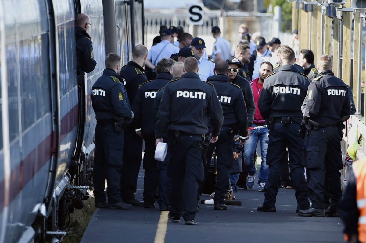 الشرطة الدنماركية تحرس قطارًا مع مهاجرين ، معظمهم من سوريا والعراق ، في محطة قطار رودبي ، جنوب الدنمارك