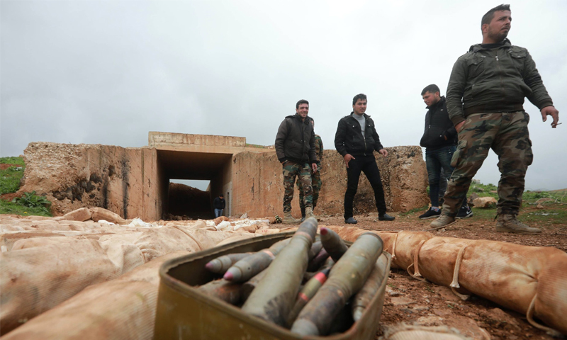 جنود سوريون يقفون قرب أسلحة وجدت في درعا - شباط 2018 (AFP)