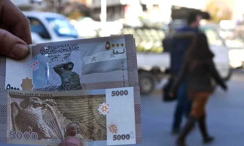 مواطن سوري يعرض عملة ورقية جديدة بقيمة 5000 ليرة سورية في دمشق - في 24 كانون الثاني 2021 (Ammar Safarjalani/Xinhua)