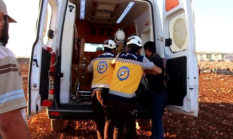 فريق "الدفاع المدني السوري" ينقل جثة شاب في 4 من تشرين الأول2021 بمحيط مخيم "الهبيط"( الدفاع المدني_فيس بوك)