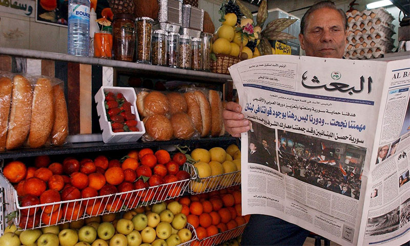 رجل سوري يقرأ جريدة "البعث" التابعة لحزب "البعث" في سوبرماركت- آذار 2005 (EPA)