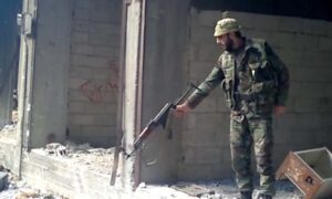 عنصر من مخابرات النظام السوري أمجد يوسف خلال قتله المدنيين في حي "التضامن" الدمشقي عام 2013 (الجارديان) 