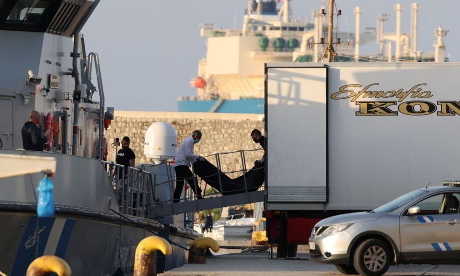 نقل أكياس جثث لأشخاص كانوا على متن القارب الغارق قبالة سواحل اليونان- 15 من حزيران 2023 (رويترز)