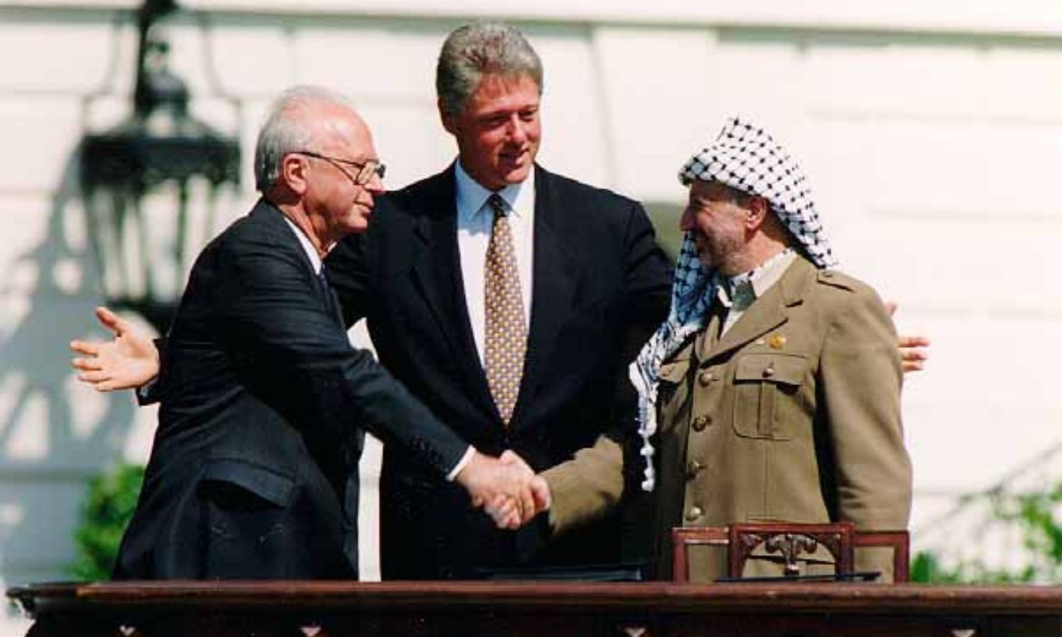 ياسر عرفات (يمين) وبيل كلينتون (وسط) وإسحاق رابين (يسار) أثناء توقيع اتفاقية أوسلو 1993