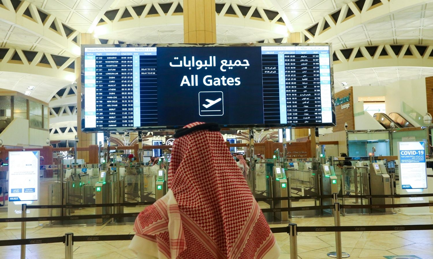 رجل سعودي يتحقق من مواعيد الرحلات في مطار الملك خالد الدولي بالرياض في المملكة العربية السعودية - 16 أيار 2021 (رويترز)