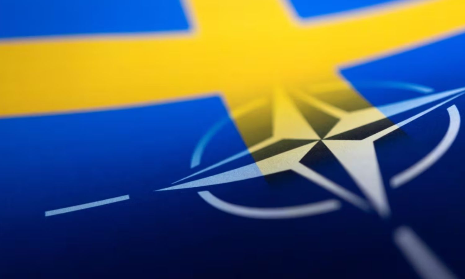 شعار حلف الشمال الأطلسي وعلم السويد - 13 من نيسان 2022 (رويترز)