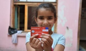 طفلة تحمل بطاقة "الهلال الأحمر" التركي (برنامج الأغذية العالمي)