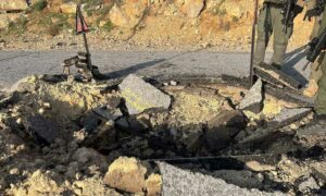 حفرة على طريق متضرر ناتجة عن هجوم إيراني بطائرات مسيرة على إسرائيل- 14 من نيسان 2024 (رويترز)