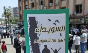 لافتة رجعها محتجون في مظاهرة وسط مدينة السويداء جنوبي سوريا- 1 من أيار 2024 (الراصد/ فيس بوك)