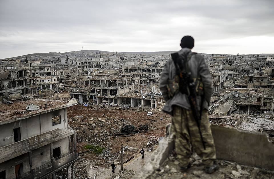 A Kurdish Syrian sniper on the roof of a destroyed building in the city of Ayn Arab, Kobani, June 2015 (France Press)