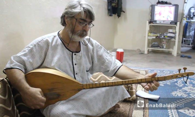 Adel Mourad, Kurdish playwright and poet, playing the tanbūra machine (long-necked lutes) (Enab Baladi)