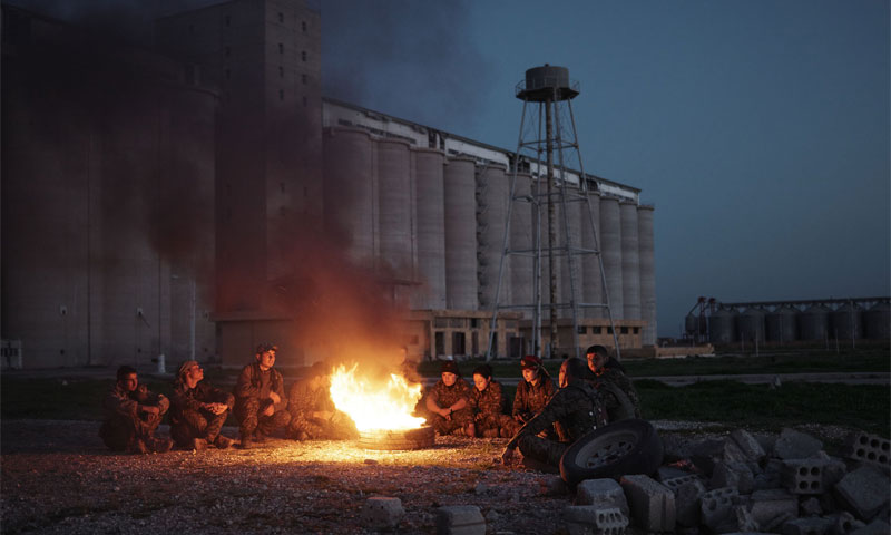 Kurdish fighters light a fire after taking control of Tell Hamis in al-Hasakah, February 2015 (The Independent)
