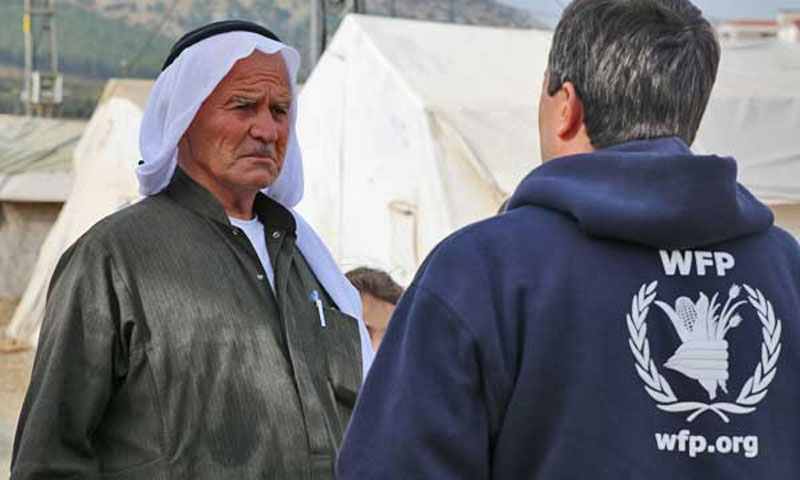 UNHCR employee in front of a Syrian elderly in a border refugee camp with Turkey (WPF)