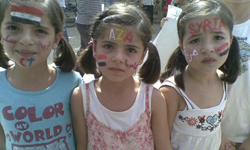 Young girls take part in a demonstration against Syria's President Bashar al-Assad  in Amude September 30, 2011. Writings on their faces read, 