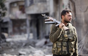 A Free Syrian Army fighter stands on a damaged street in Aleppo in November.