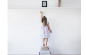 Young girl reaching for electronic book reader