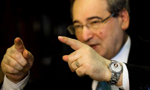 نائب وزير الخارجية، فيصل المقداد يرتدي ساعة تحمل صورة الأسد خلال مقابلة مع وكالة 