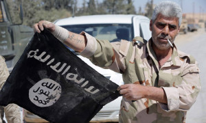 مقاتل في قوات الأسد يحمل راية تنظيم 