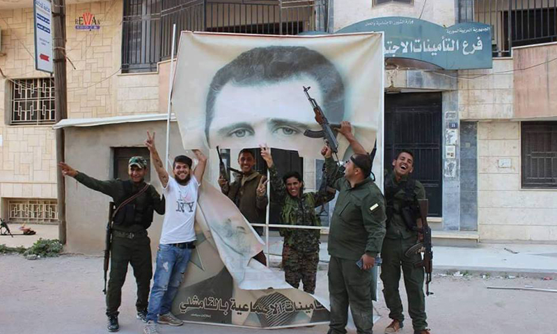 إزالة صورة بشار الأسد من مبنى التامينات الاجتماعية في مدينة القامشلي، الأربعاء 20 نيسان.